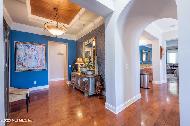 3808 Catania Pl, Jacksonville, FL 32224 - hall with baseboards, arched walkways, hardwood / wood-style flooring, crown molding, and a raised ceiling