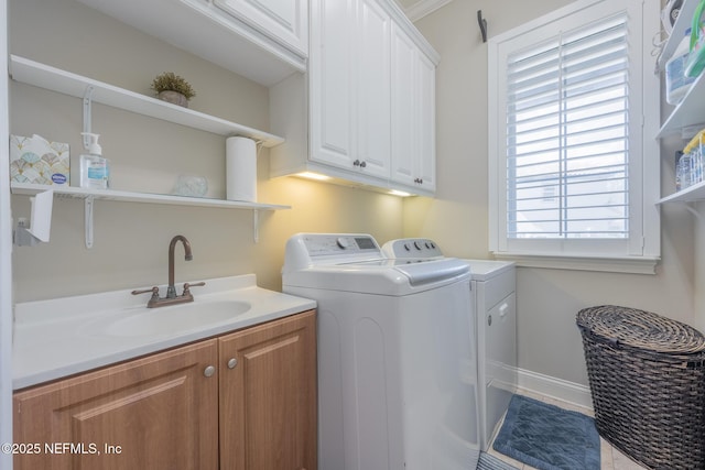 3808 Catania Pl, Jacksonville, FL 32224 - clothes washing area featuring cabinet space, washer and dryer, baseboards, and a sink