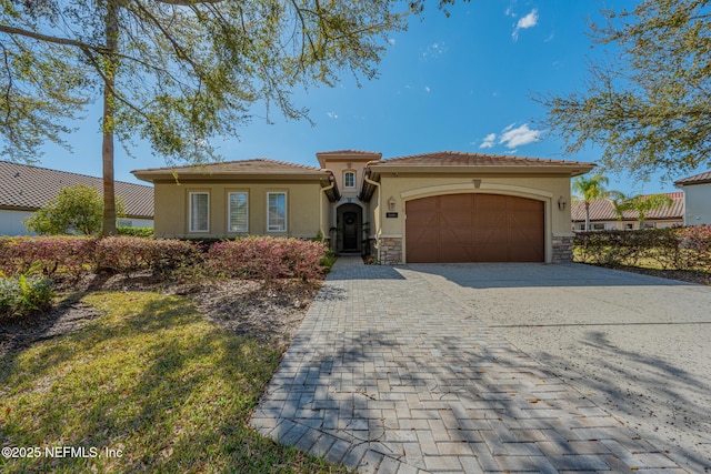3808 Catania Pl, Jacksonville, FL 32224 - mediterranean / spanish home with stucco siding, decorative driveway, stone siding, an attached garage, and a tiled roof