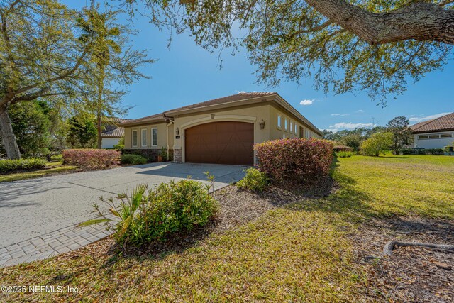 3808 Catania Pl, Jacksonville, FL 32224 - mediterranean / spanish home with a front yard, stucco siding, a garage, stone siding, and driveway