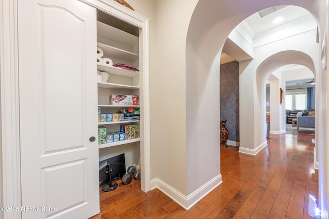 3808 Catania Pl, Jacksonville, FL 32224 - hall featuring baseboards, arched walkways, crown molding, and hardwood / wood-style flooring