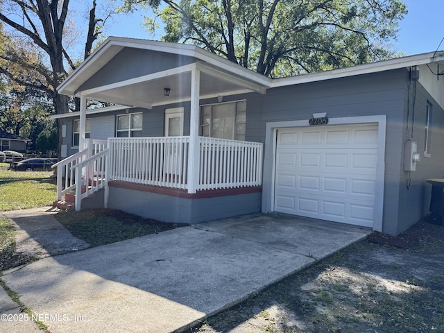 view of front of home featuring covered porch, concrete driveway, and an attached garage