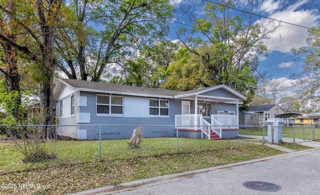 view of front facade with a carport, a fenced front yard, a porch, and a front lawn