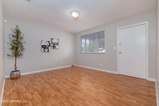 empty room with baseboards and light wood-style floors