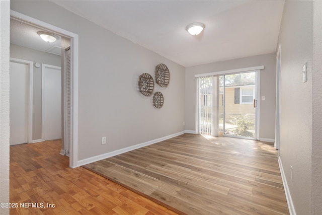 empty room featuring baseboards and light wood finished floors