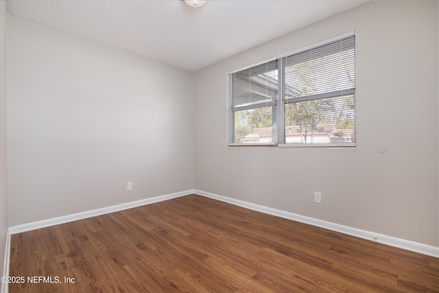 unfurnished room with wood finished floors and baseboards