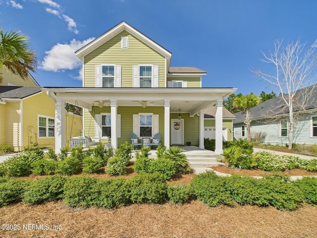view of front of property with a garage, covered porch, and a ceiling fan