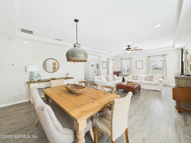 dining space with visible vents, baseboards, ceiling fan, and wood finished floors