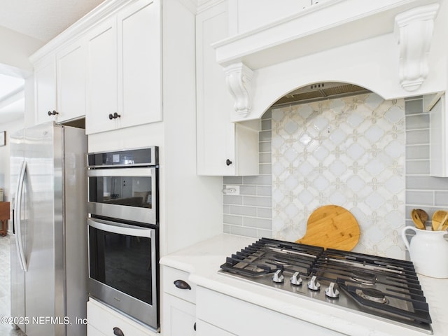 kitchen featuring decorative backsplash, appliances with stainless steel finishes, white cabinetry, and light countertops
