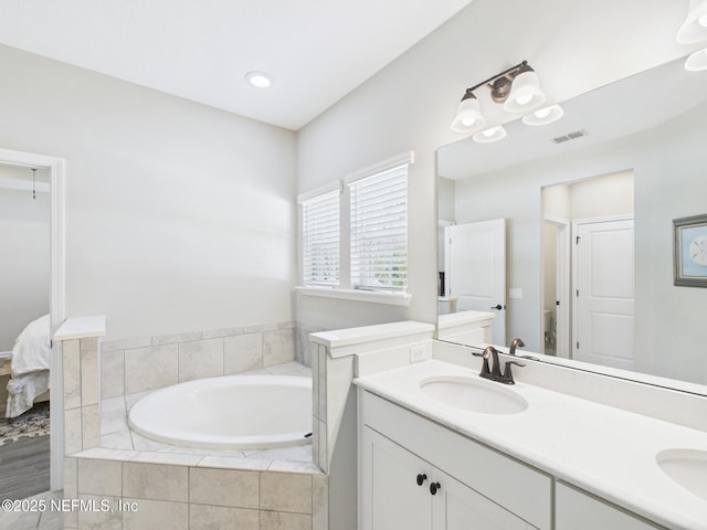 bathroom featuring double vanity, a bath, visible vents, and a sink