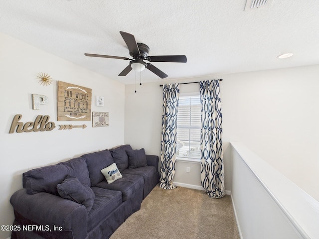 living area featuring visible vents, ceiling fan, baseboards, carpet, and a textured ceiling