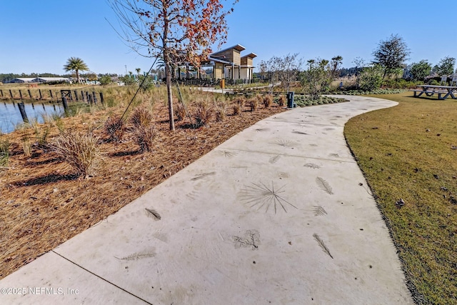 view of community featuring a lawn and driveway