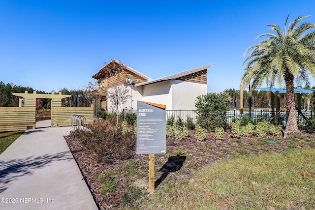 view of front of property featuring stucco siding and fence