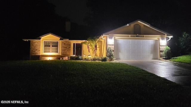 view of front of house with a lawn, concrete driveway, and a garage