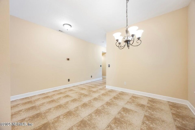 unfurnished room with baseboards and a chandelier