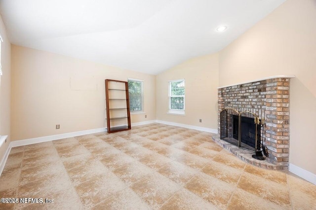 unfurnished living room featuring lofted ceiling, a fireplace, and baseboards