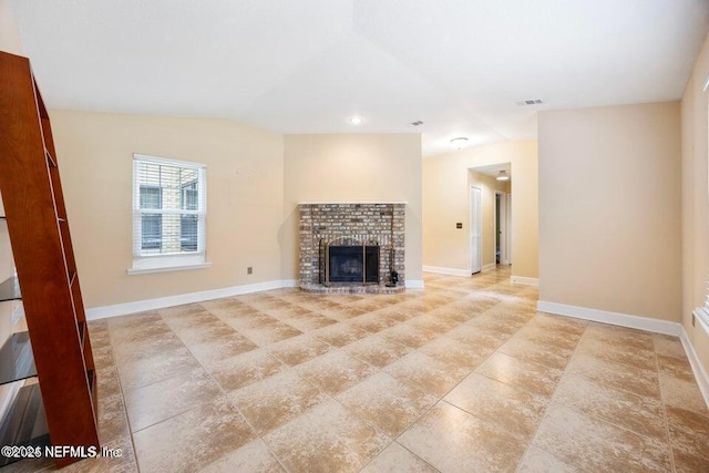 unfurnished living room with visible vents, a brick fireplace, and baseboards