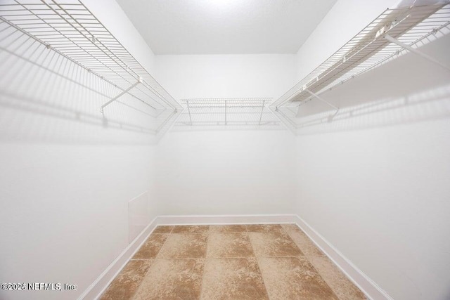 walk in closet with stone finish floor