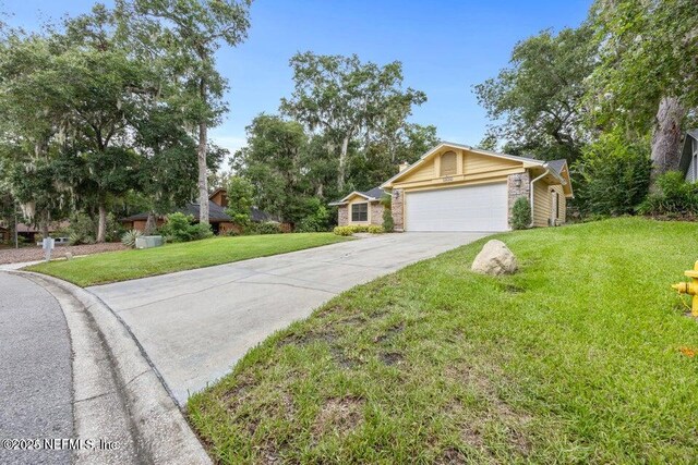 ranch-style house with a front lawn, concrete driveway, and a garage