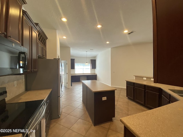 kitchen featuring light tile patterned floors, recessed lighting, electric stove, black microwave, and a center island