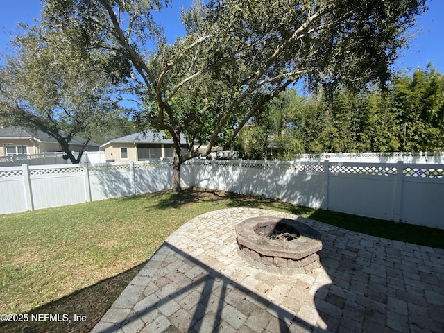 view of yard featuring a patio, a fenced backyard, and an outdoor fire pit