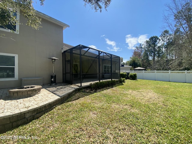 view of yard featuring a lanai, a patio, an outdoor fire pit, and a fenced backyard