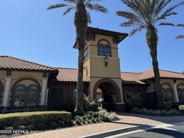 exterior space with stucco siding and a tiled roof