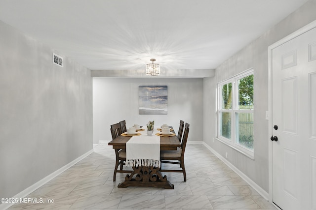 dining area featuring visible vents, a notable chandelier, baseboards, and marble finish floor