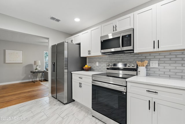 kitchen with visible vents, marble finish floor, white cabinetry, stainless steel appliances, and light countertops