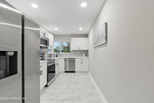 kitchen featuring backsplash, light countertops, stainless steel appliances, marble finish floor, and white cabinetry