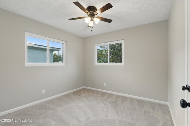 carpeted empty room with baseboards, a textured ceiling, and ceiling fan