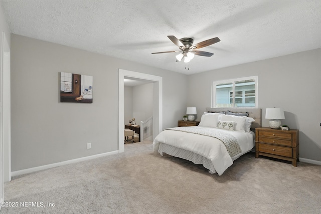 carpeted bedroom with a ceiling fan, baseboards, and a textured ceiling