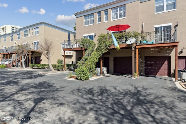 view of property featuring stucco siding, a garage, and driveway