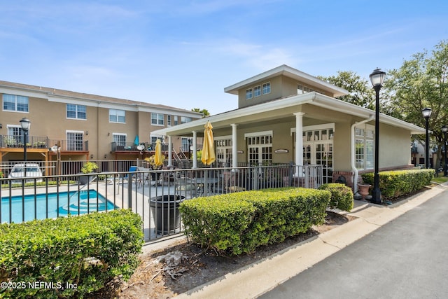 view of building exterior featuring a community pool and fence