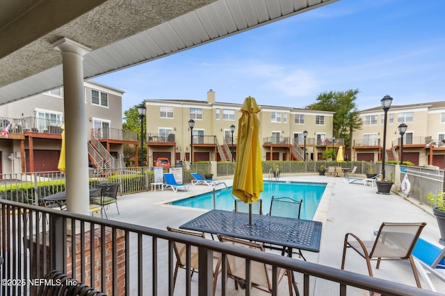 pool with a patio and fence