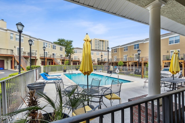 community pool featuring a patio and fence