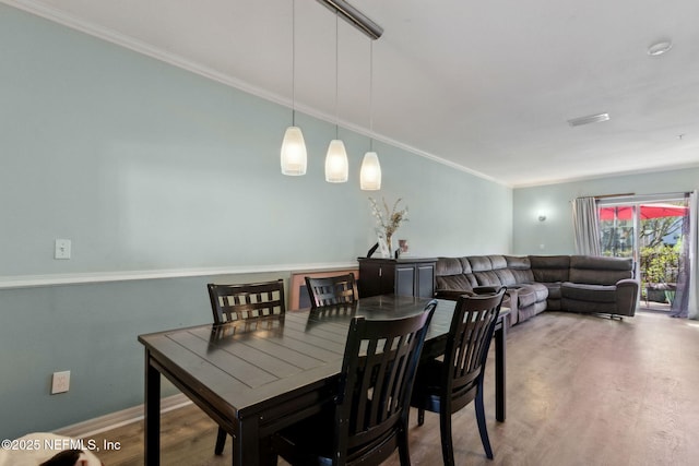 dining space featuring visible vents, wood finished floors, baseboards, and ornamental molding