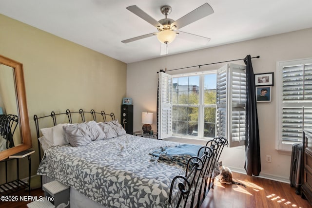 bedroom with a ceiling fan, baseboards, and wood finished floors