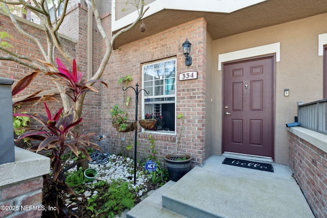 entrance to property featuring brick siding