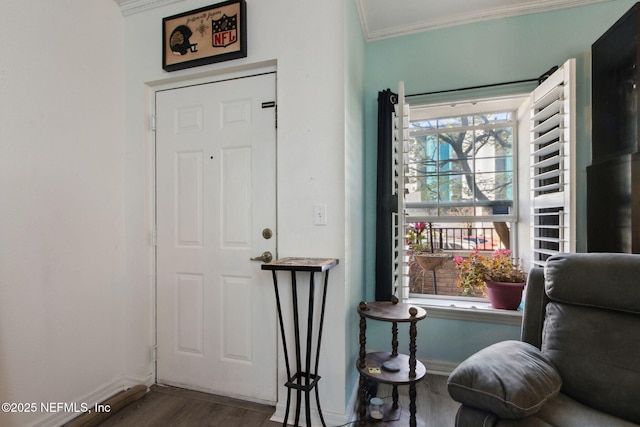 living area with baseboards, wood finished floors, and ornamental molding