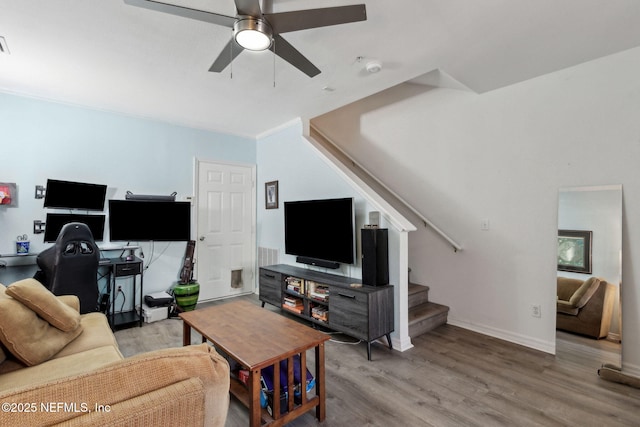 living area featuring visible vents, wood finished floors, baseboards, ceiling fan, and stairs