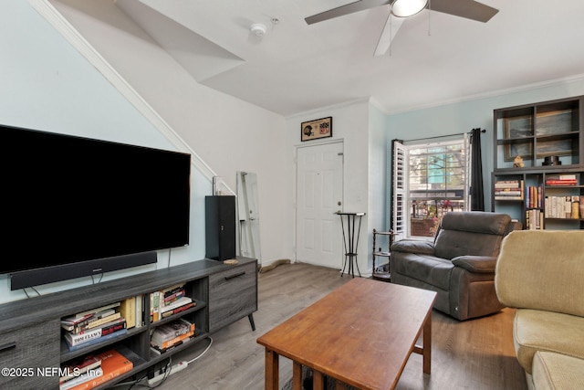 living area featuring light wood-type flooring, a ceiling fan, and crown molding