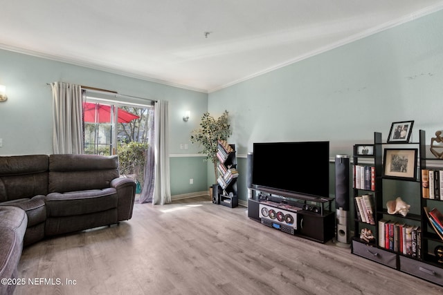 living area featuring baseboards, wood finished floors, and crown molding