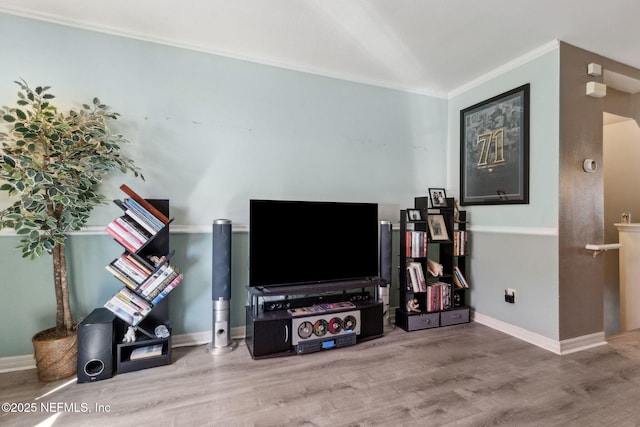 living room with baseboards, wood finished floors, and crown molding