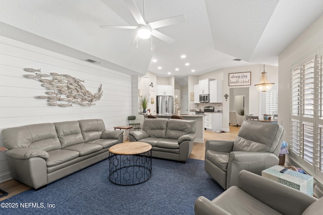 living room with recessed lighting, visible vents, ceiling fan, and light wood-style flooring