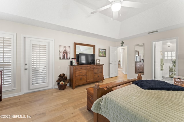 bedroom with visible vents, lofted ceiling, light wood-style flooring, a raised ceiling, and access to outside