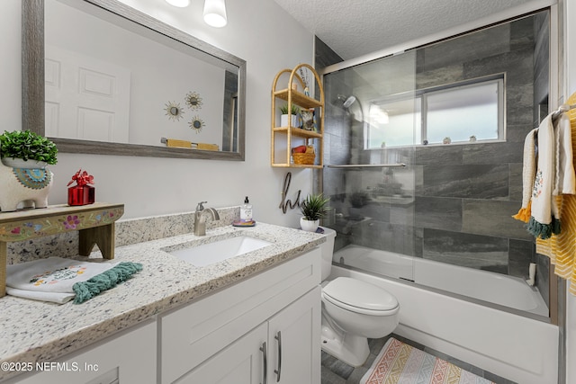 bathroom featuring vanity, enclosed tub / shower combo, toilet, and a textured ceiling