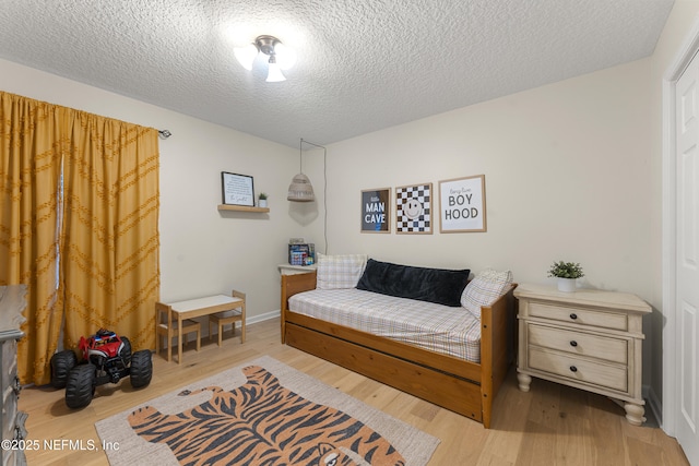 bedroom featuring a textured ceiling and wood finished floors