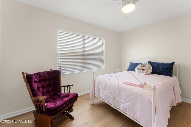 bedroom featuring a ceiling fan, wood finished floors, and baseboards