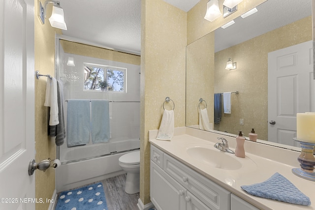 bathroom with toilet, vanity, wood finished floors, shower / bath combination with glass door, and a textured ceiling